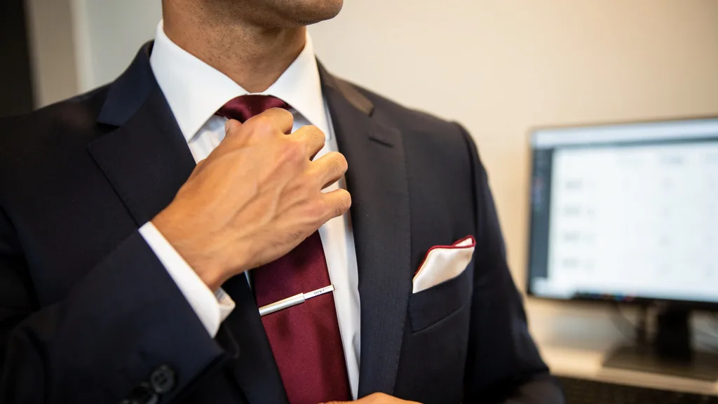 Click to manage / replace image A close-up shot focusing on the chest area of a man wearing a navy suit